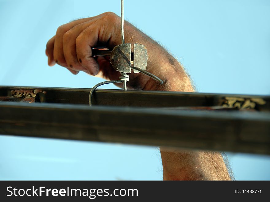 Worker dirty hand with nippers and wire. Worker dirty hand with nippers and wire