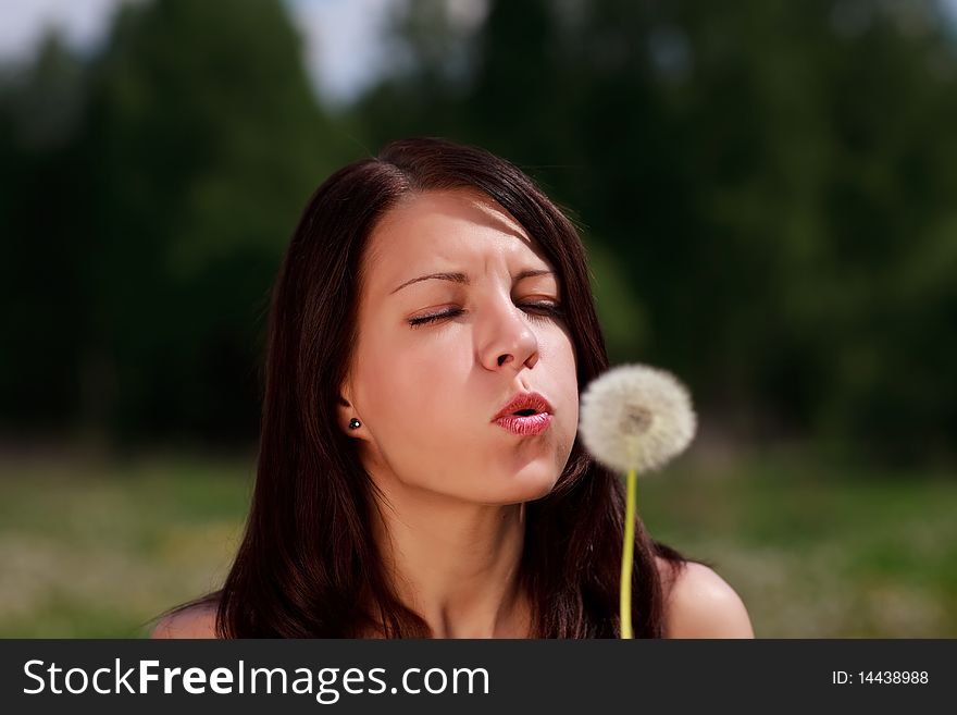 Girl with blowball, background is out of focus. Girl with blowball, background is out of focus