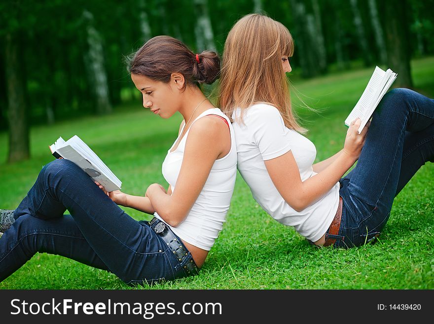 Two young pretty girls reading books. Two young pretty girls reading books