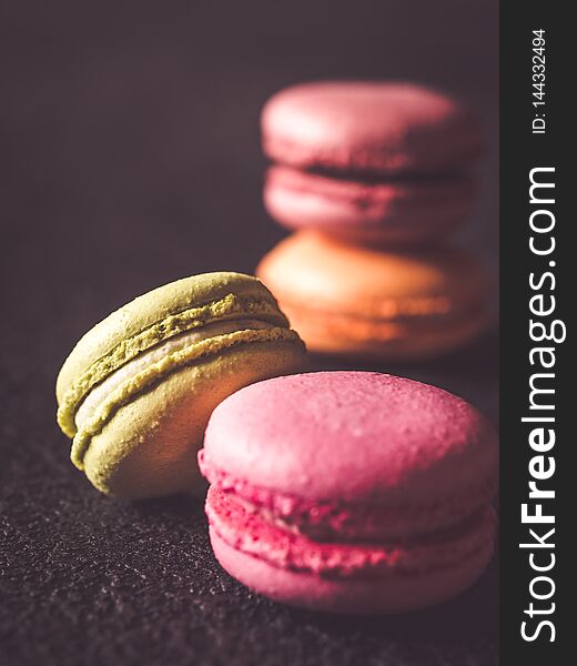 Colorful macarons on the dark wooden background close up. Colorful macarons on the dark wooden background close up