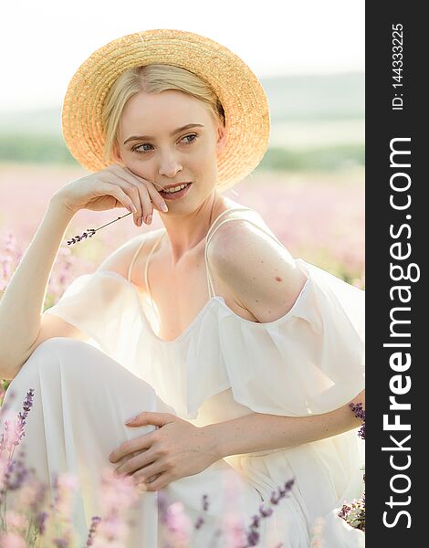 Wonderful portrait of girl in light dress in lavender field on golden sunset