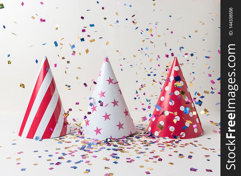 Colored confetti and party hat on white background. Minimal party concept