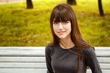 Portrait Of A Young Woman Sitting In The Park On A Bench Stock Photos