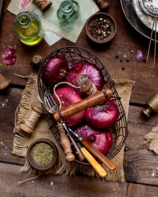 Overhead Shot Of Basket Of Red Onion Standing On Wooden Brown Table With Sackcloth Stock Photos