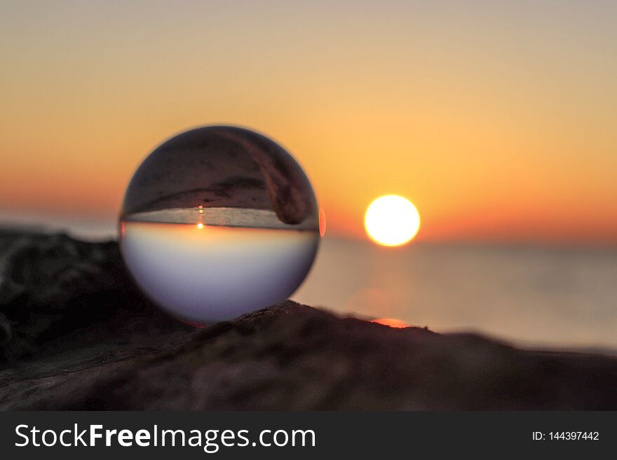Colorful sunrise through a lensball on the beach. Colorful sunrise through a lensball on the beach