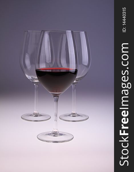 Image of wine glasses, one filled with red wine.