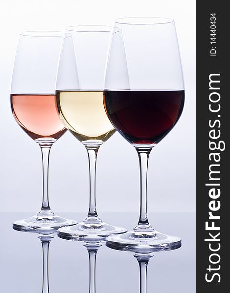 Elegant crystal wine glasses filled with red, pink and white wine. Elegant crystal wine glasses filled with red, pink and white wine.