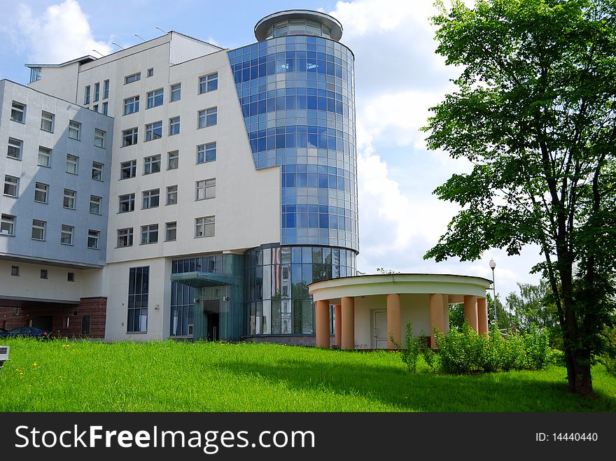 Modern office building against a lawn and the blue sky