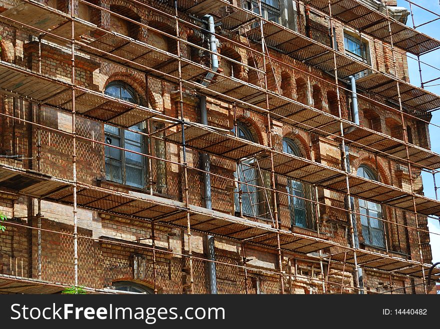 scaffolds round an old brick building