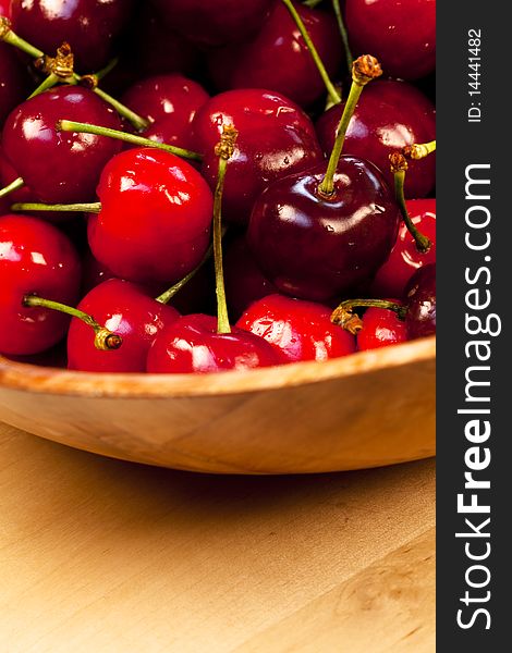 Close up with cherries on a wooden bowl