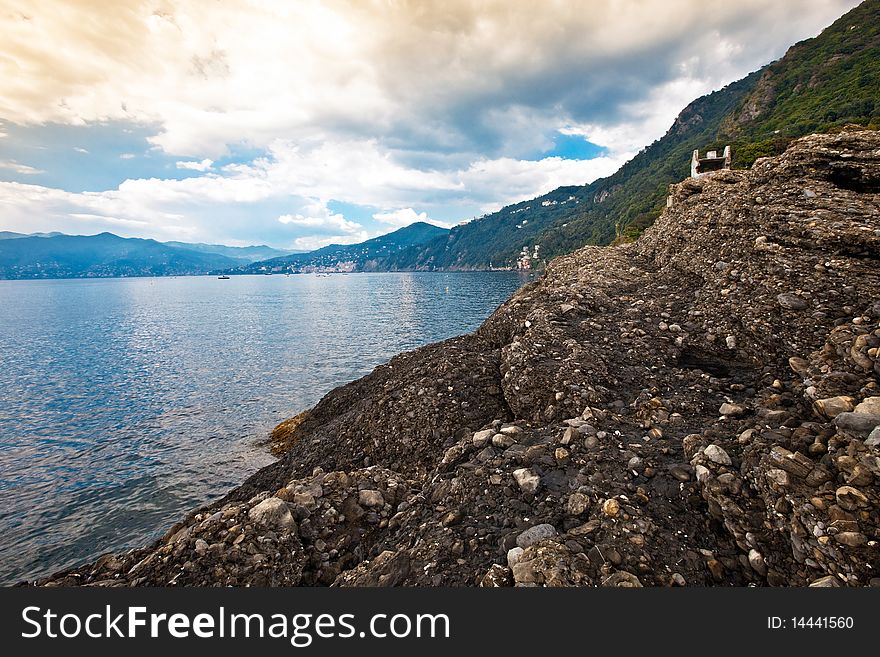 The rocks on the extreme promontory that divides the gulf of Tigullio from Golfo Paradiso in Italian Riviera. The rocks on the extreme promontory that divides the gulf of Tigullio from Golfo Paradiso in Italian Riviera