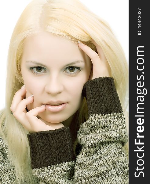 Young blonde woman in sweater with make-up on white background