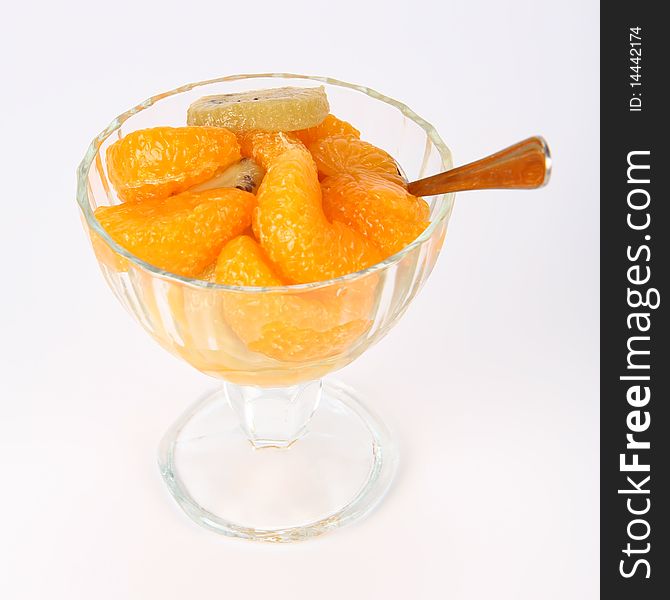 Fruit salad with a spoon on white background