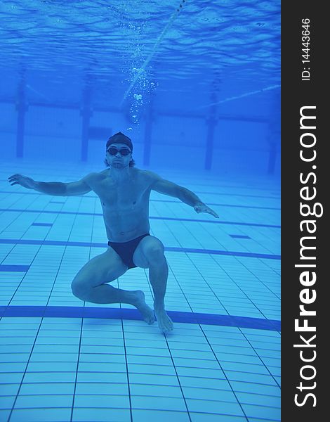 Undervater shoot of swimming pool with good looking young swimmer. Undervater shoot of swimming pool with good looking young swimmer