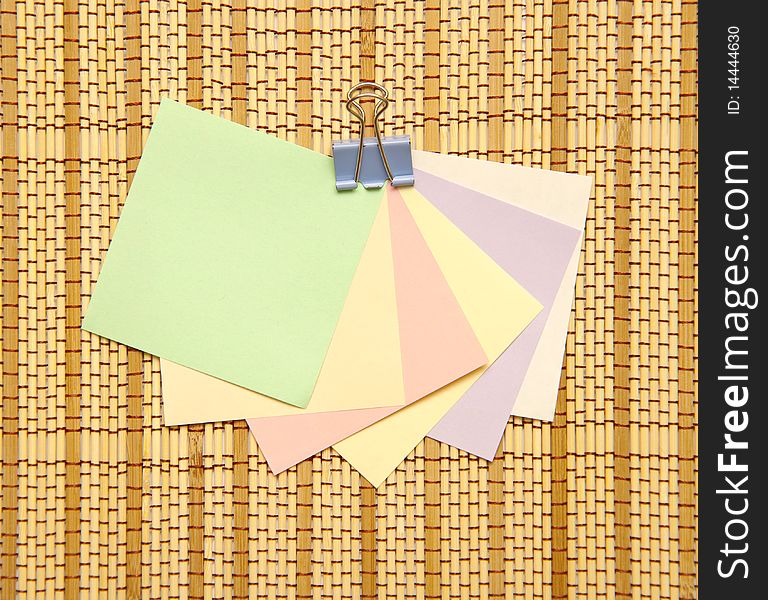 Colourful Notes with paper clip on straw rug