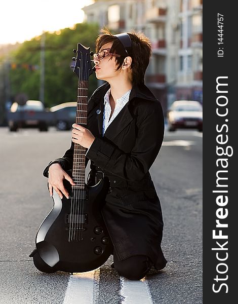 Pretty Young Brunette Girl Kissing A Guitar