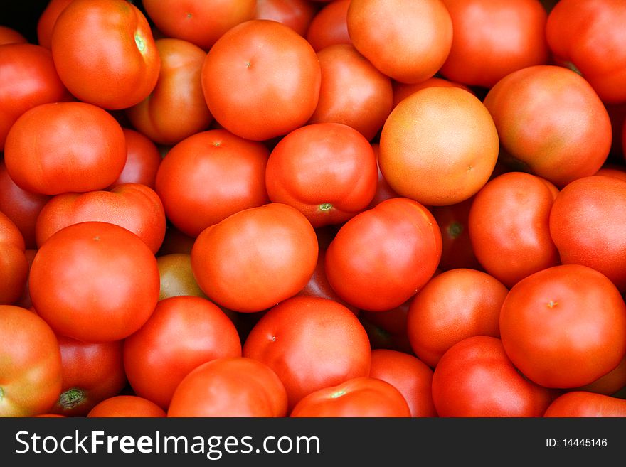 Many red tomatoes in the foreground