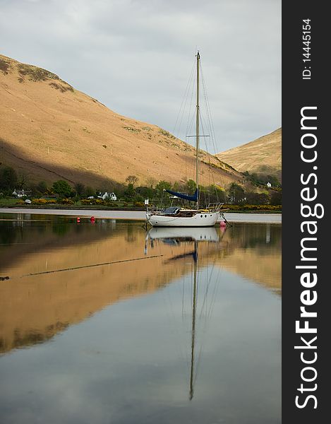 Boat on Loch with reflections and copy space.