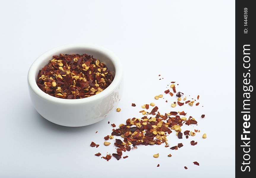 Crushed Chillies In A White Dish, On A White Background