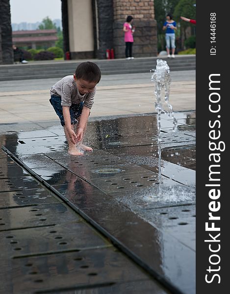 Happy asian boy play by Fountain