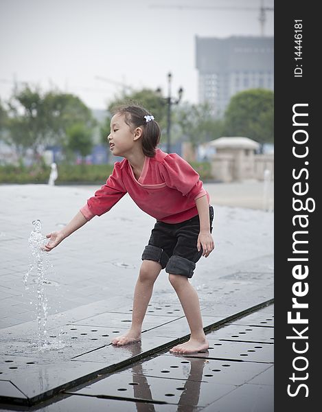 Happy asian girl play by Fountain