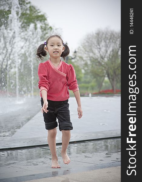 Happy asian girl play by Fountain