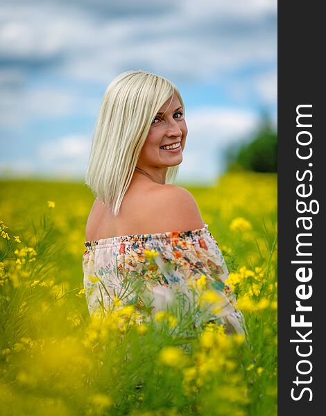 Soft, selective focus. Beautiful, attractive, blond woman in a yellow flower meadow