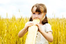 Girl Eating A Long Loaf Royalty Free Stock Images