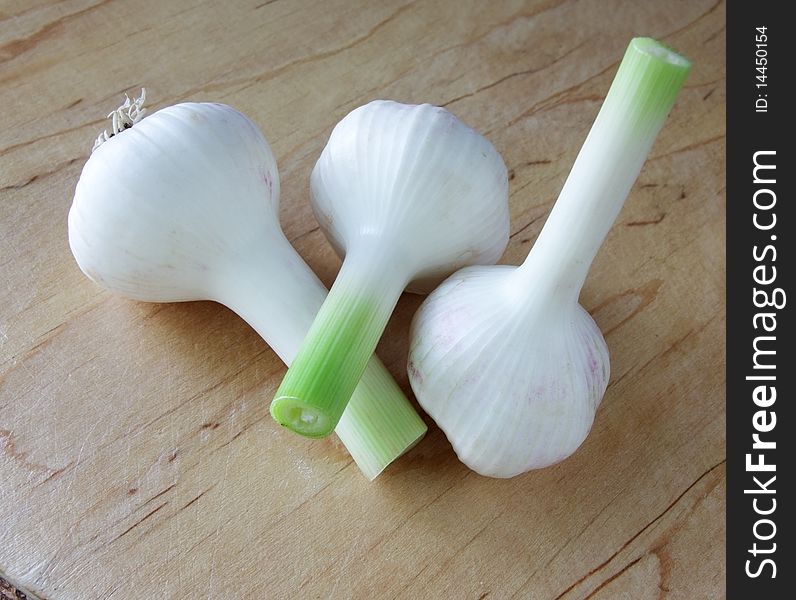 Three garlic clove on a kitchen board