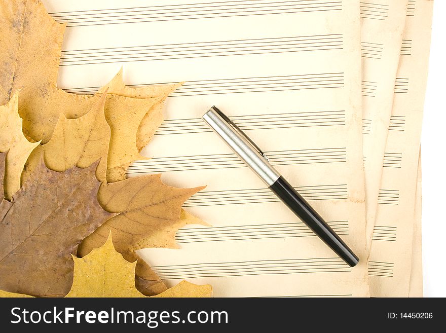 Old sheet music sheet of paper which has a handle and the autumn leaves of maple. Old sheet music sheet of paper which has a handle and the autumn leaves of maple
