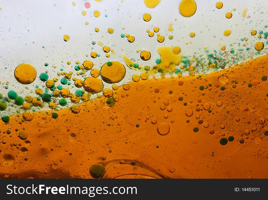 Amber colored liquid with bubbles in amber and green on white background. Amber colored liquid with bubbles in amber and green on white background