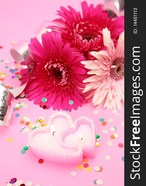 Flowers and candles on a pink background