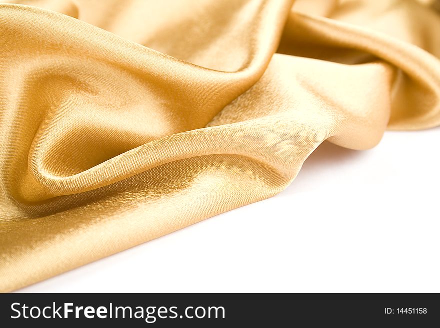 Luxurious gold satin folded cloth, useful for backgrounds. Isolated. Luxurious gold satin folded cloth, useful for backgrounds. Isolated