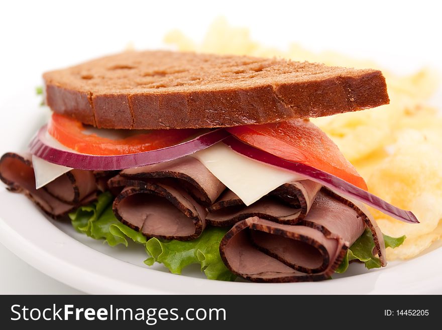 Delicious roast beef sandwich platter with whole wheat bread and potato chips. Delicious roast beef sandwich platter with whole wheat bread and potato chips