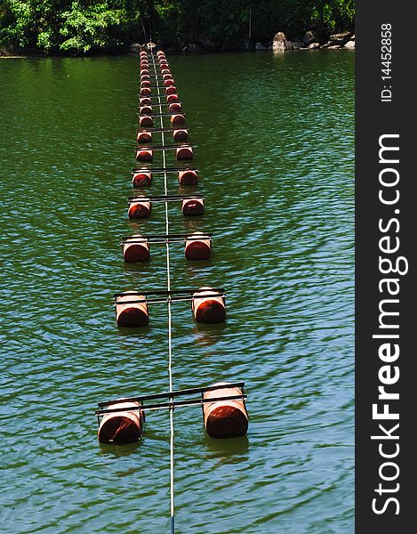 Floating buoy across river protect boats from dam.