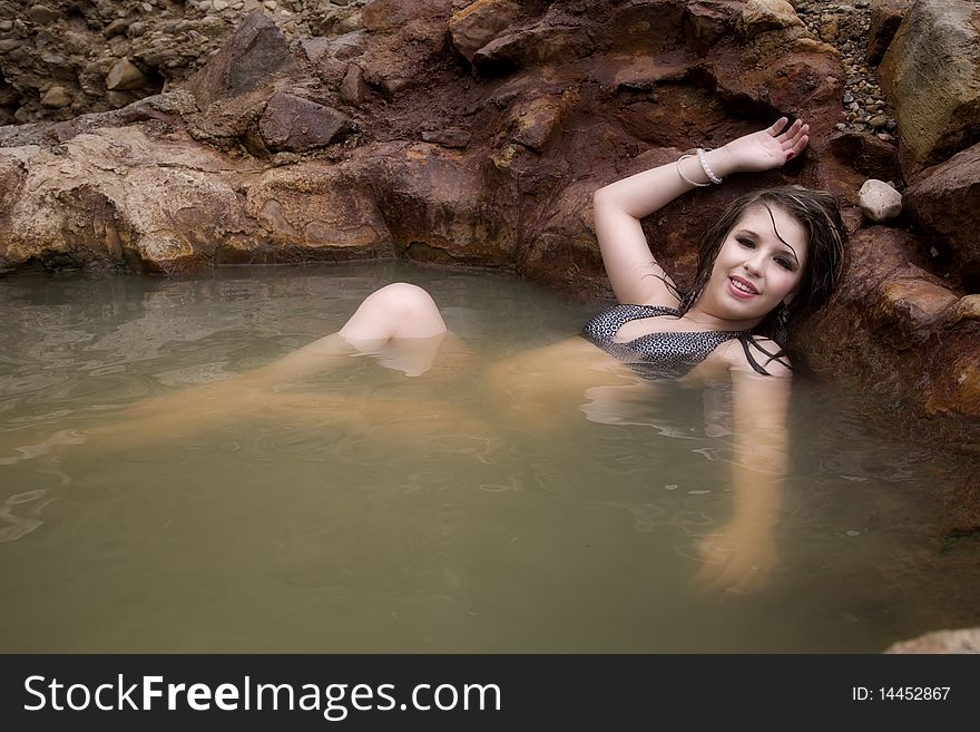 A woman is sitting in a pool with wet hair and relaxing. A woman is sitting in a pool with wet hair and relaxing.