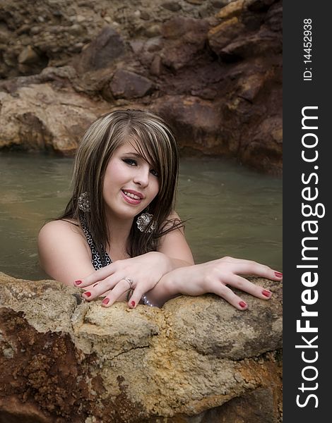 A woman is leaning on the wall of a pool smiling. A woman is leaning on the wall of a pool smiling.