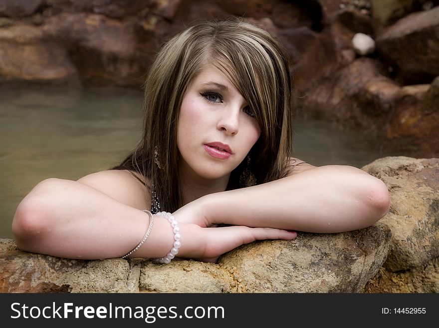 A woman is leaning on the wall of a pool. A woman is leaning on the wall of a pool.