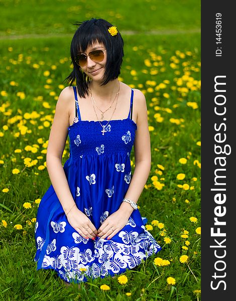 Summer girl in a blue dress against a background of green grass. Summer girl in a blue dress against a background of green grass