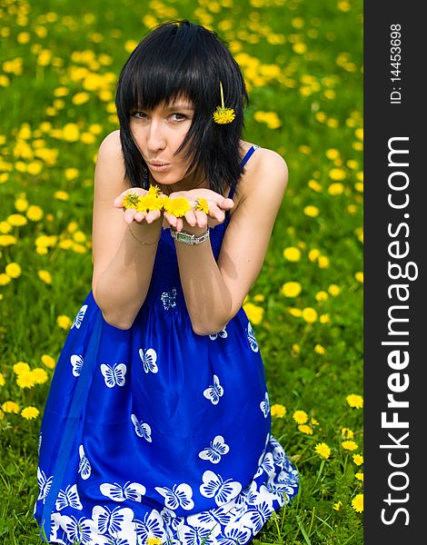 Summer girl in a blue dress against a background of green grass. Summer girl in a blue dress against a background of green grass