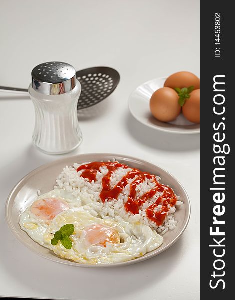 Tasty fried eggs with rice and tomato