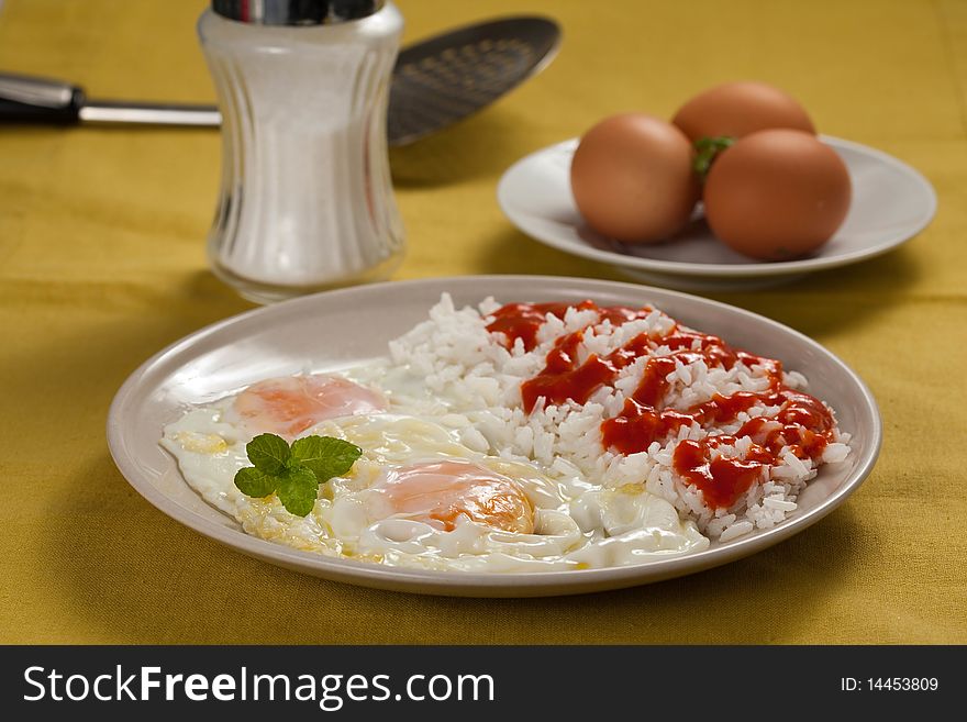 Tasty fried eggs with rice and tomato