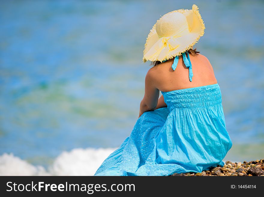 Young girl sitting near the sea