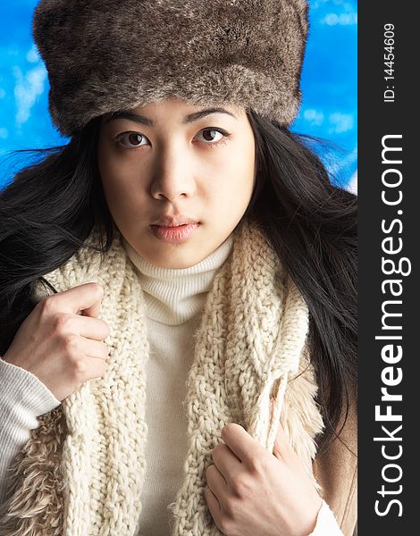 Young Woman Wearing Warm Winter Clothes And Fur Hat In Studio. Young Woman Wearing Warm Winter Clothes And Fur Hat In Studio