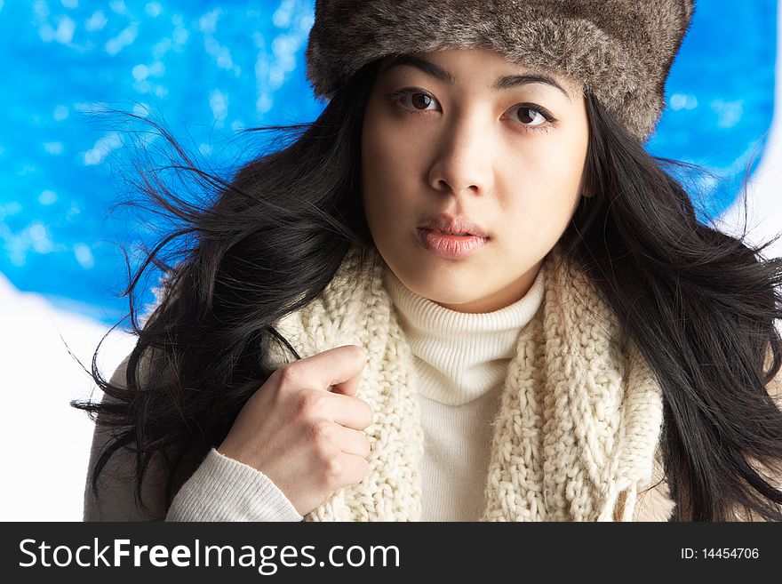 Young Woman Wearing Warm Winter Clothes And Fur Hat In Studio. Young Woman Wearing Warm Winter Clothes And Fur Hat In Studio