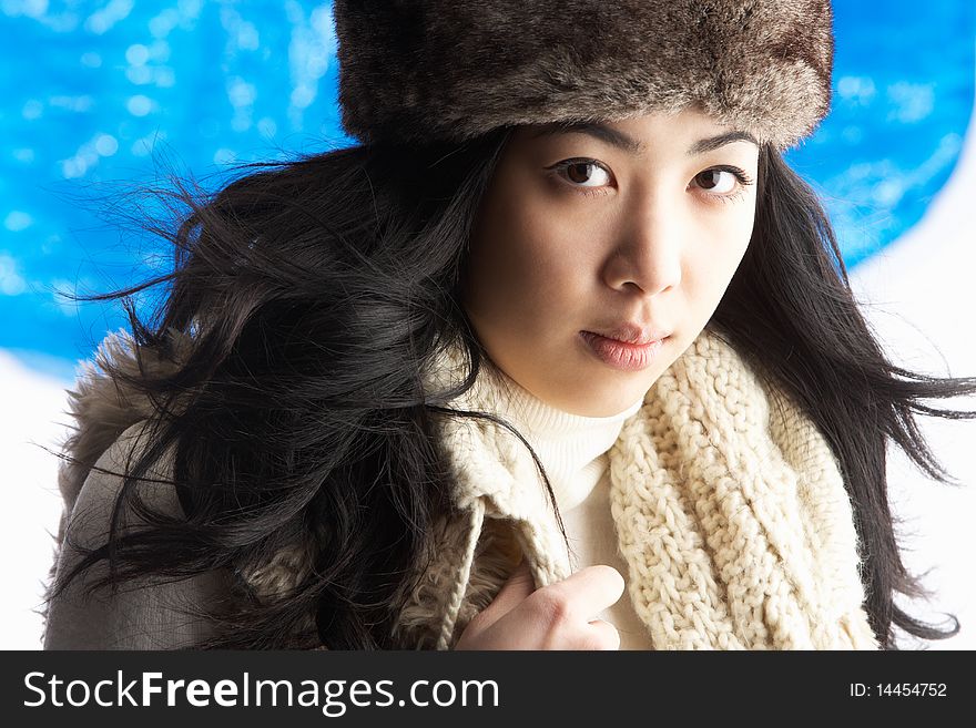 Young Woman Wearing Warm Winter Clothes And Fur Hat In Studio. Young Woman Wearing Warm Winter Clothes And Fur Hat In Studio