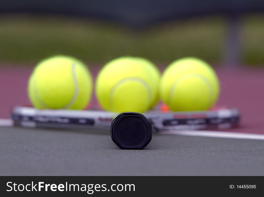 Tennis balls on a racket on the court ground. Tennis balls on a racket on the court ground.