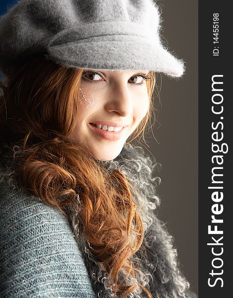 Fashionable Teenage Girl Wearing Cap And Knitwear In Studio