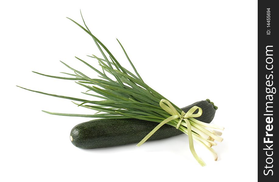 A bunch of green onions and zucchini on a white background