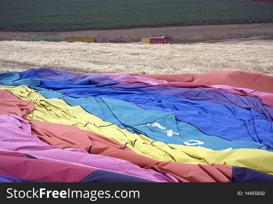 Hot air balloon laying in the field